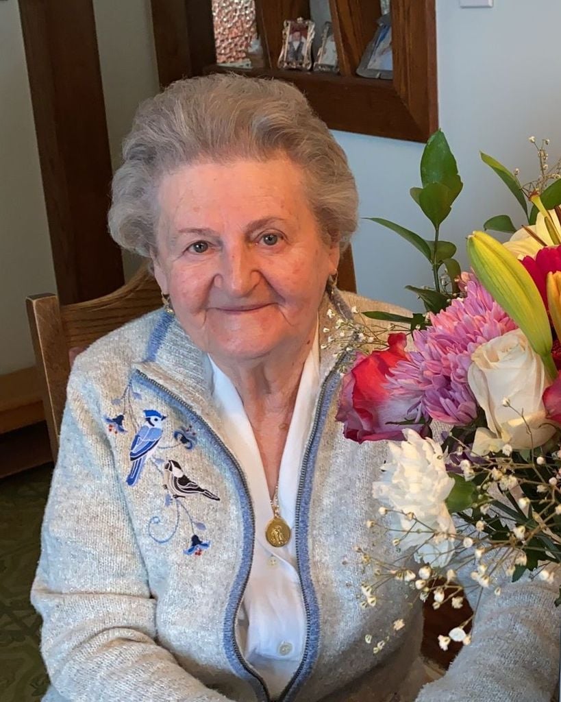 Smiling old woman with flowers