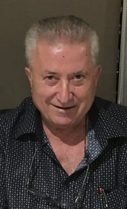 Older man with a smile, wearing a dark golf shirt