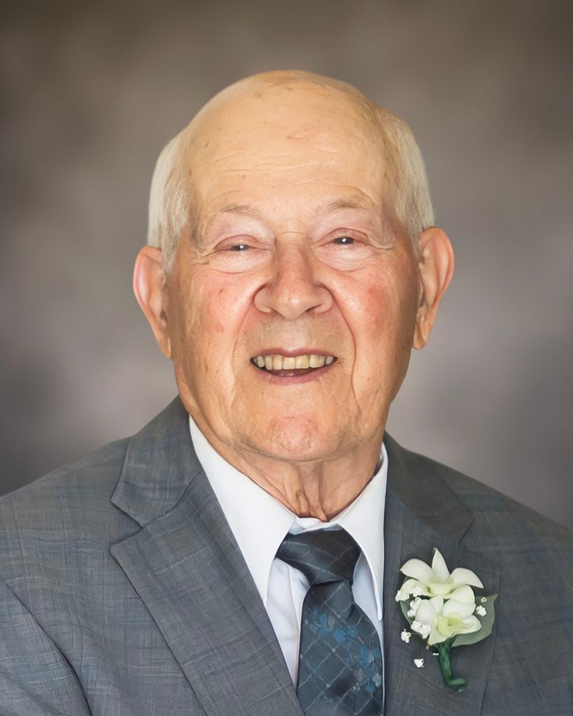 smiling older man wearing grey suit