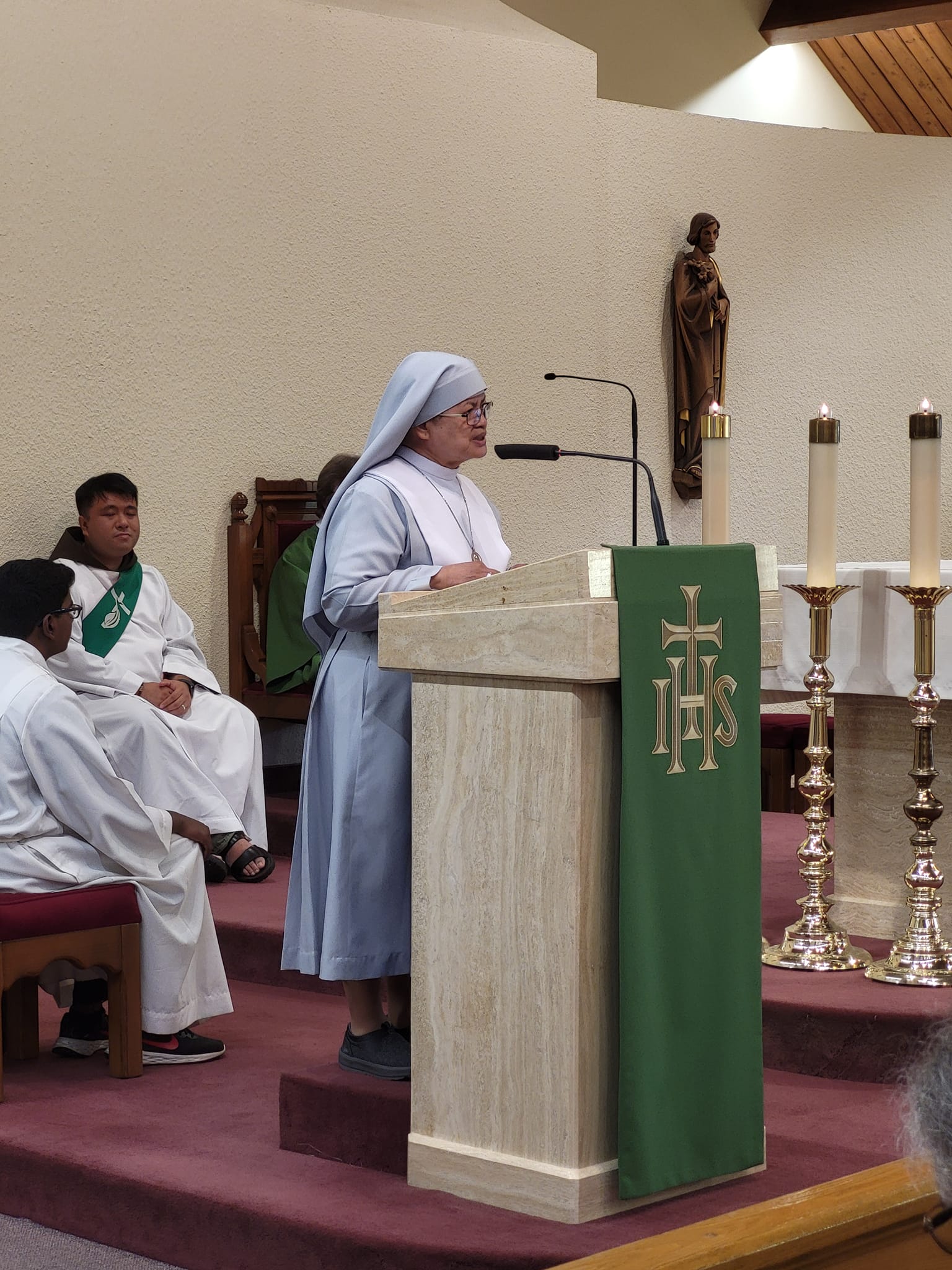 nun in blue habit at lectern