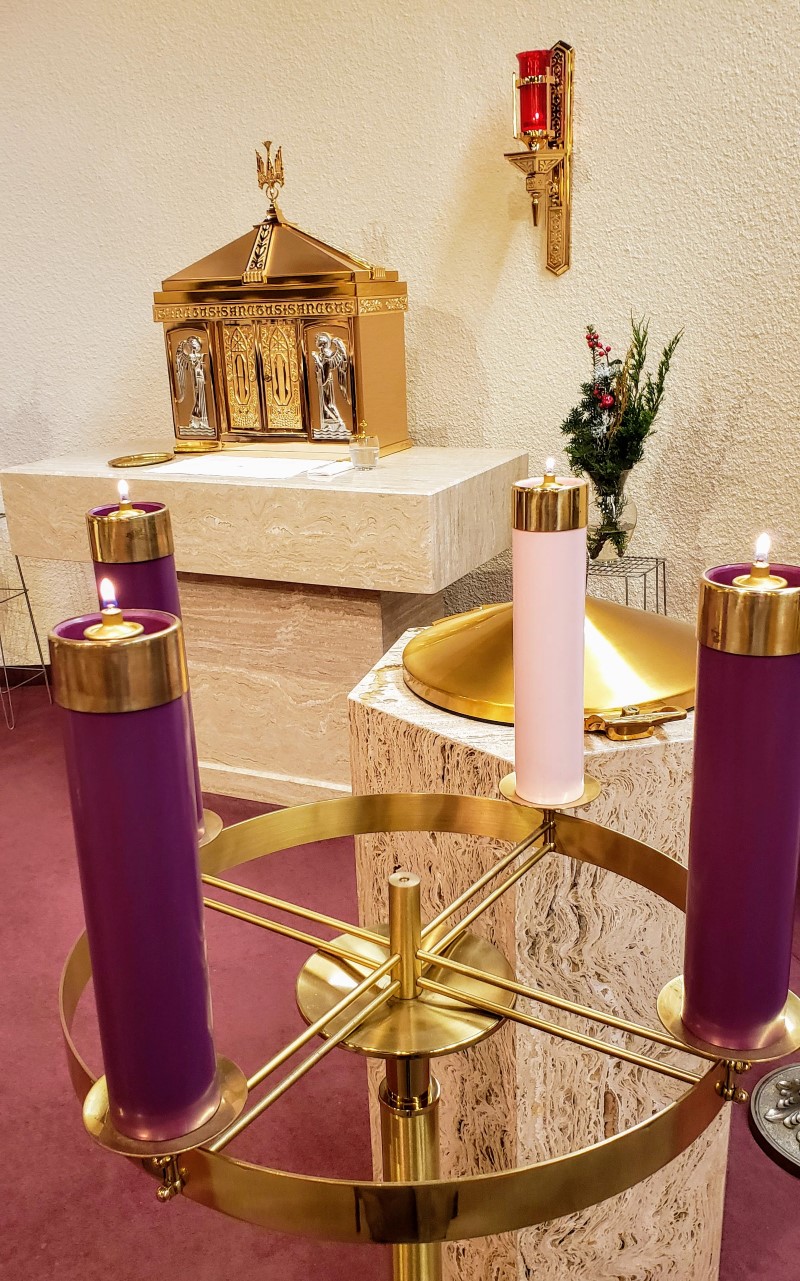 fourth week advent wreath, 3 purple candles lit, 1 pink candle lit