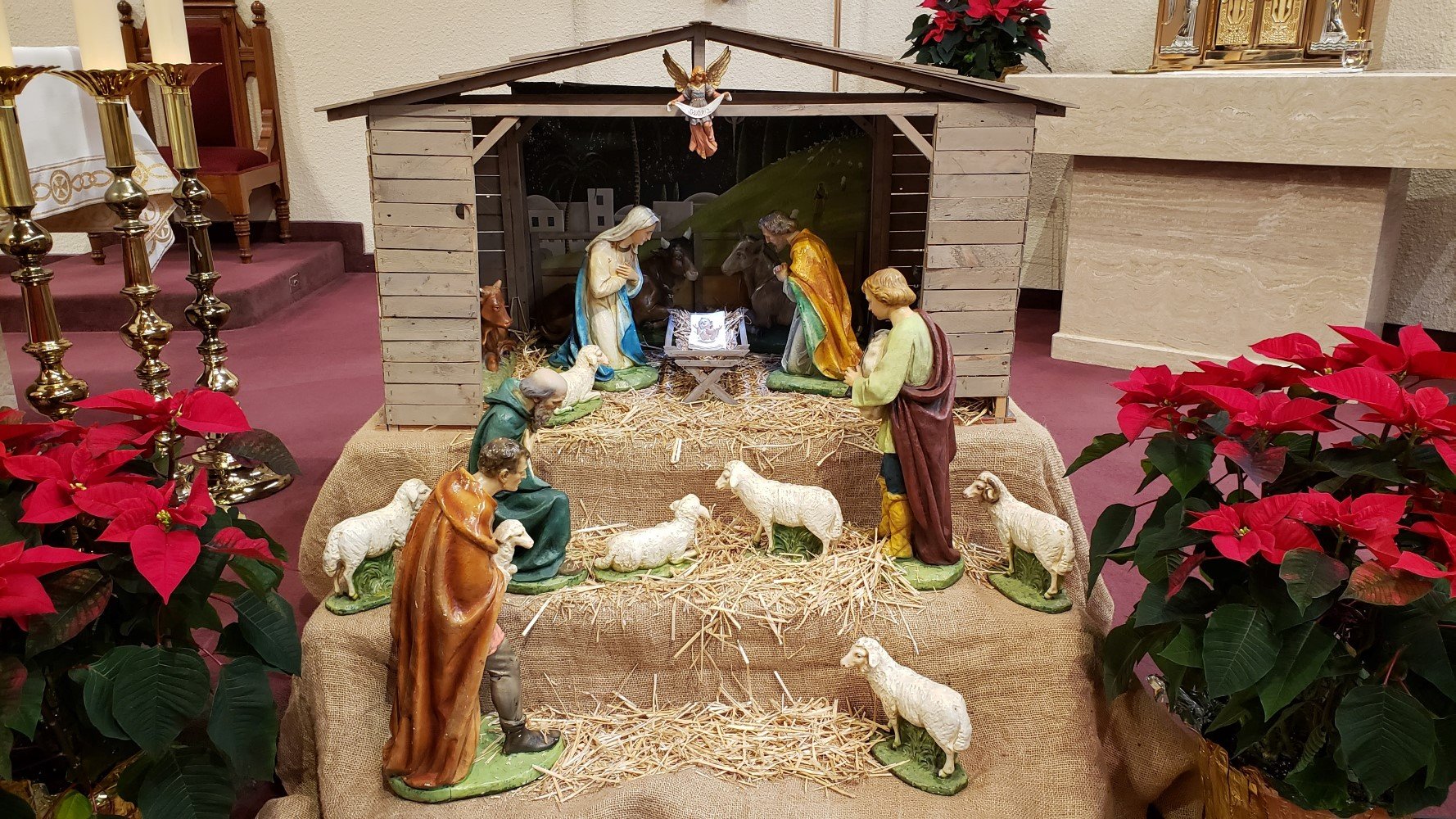 Mary, Joseph looking at baby Jesus.  Shepherds and sheep are also looking at Him from different levels