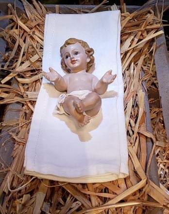 Statue of Baby Jesus in a mound of yellow hay