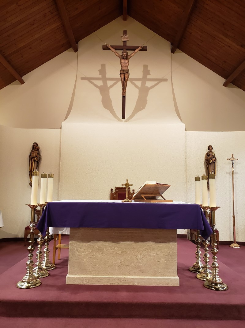This is a picture of an altar with purple frontal and crucifix hanging above