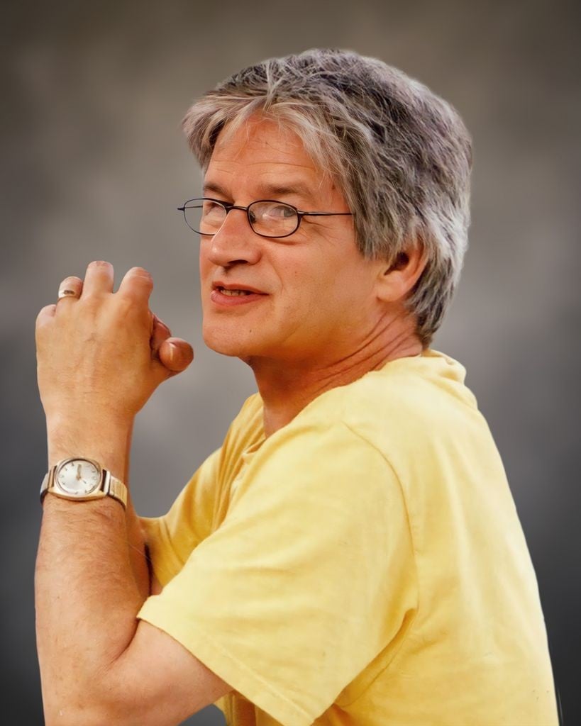 Sideways view of man with gray hair, wearing a yellow shirt